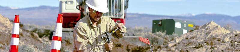 Worker installing cables for underground distribution.